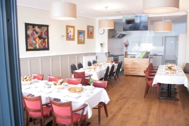 De Huiskamer met gedekte tafels en de open keuken